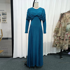 Blue evening gown on a mannequin against a white curtain background
