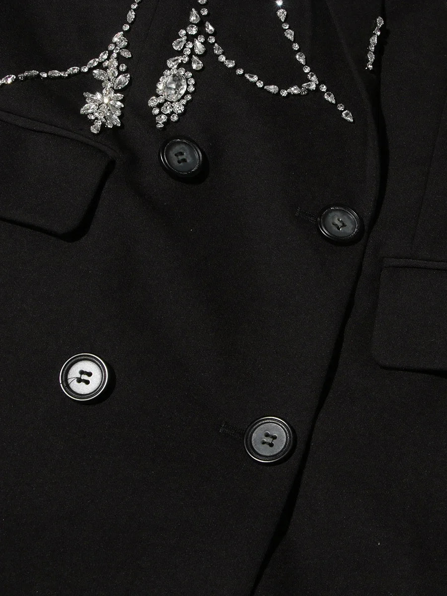 Close-up of a black coat with decorative buttons and embellishments.