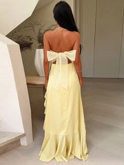 Woman wearing a yellow dress with a bow detail in an indoor setting