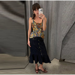 Model wearing a floral print peplum top and denim midi skirt in a fitting room