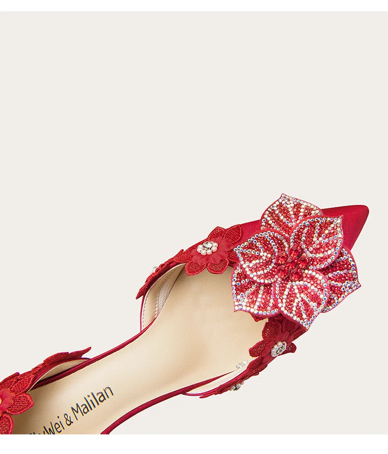 Red high-heeled shoe with floral embellishments on a white background