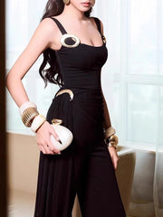 Woman wearing a black dress with gold accents indoors