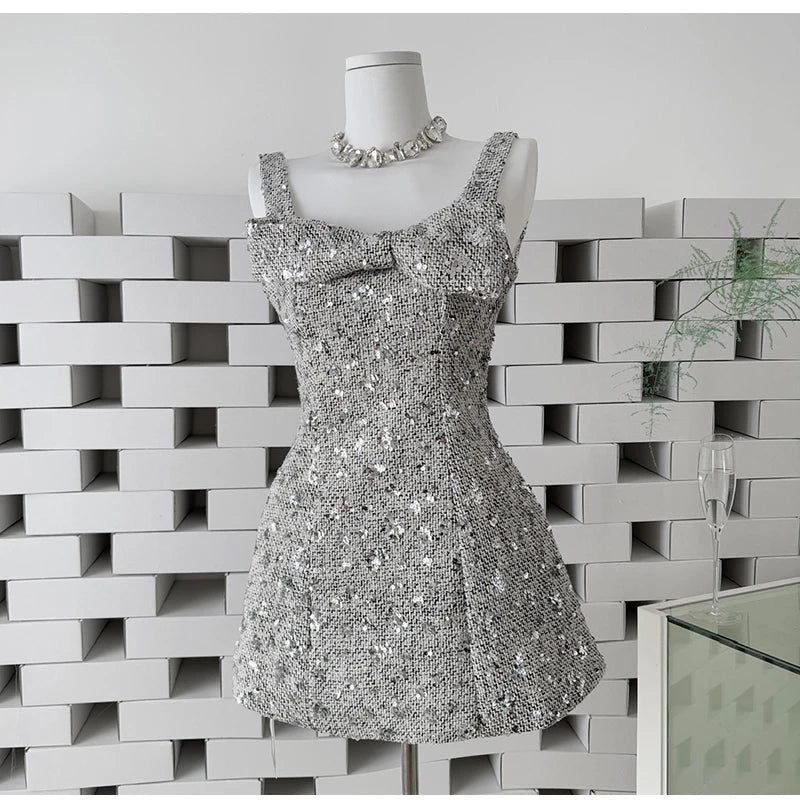 Silver sequin mini dress with bow detail on a mannequin