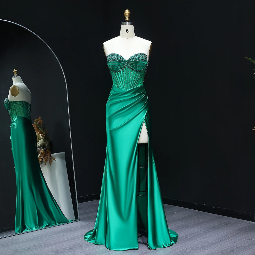 Green evening gown on a mannequin against a black background