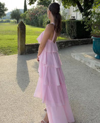 Woman in a pink dress standing in a garden setting