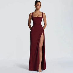Woman wearing a burgundy evening gown with a high slit on a white background