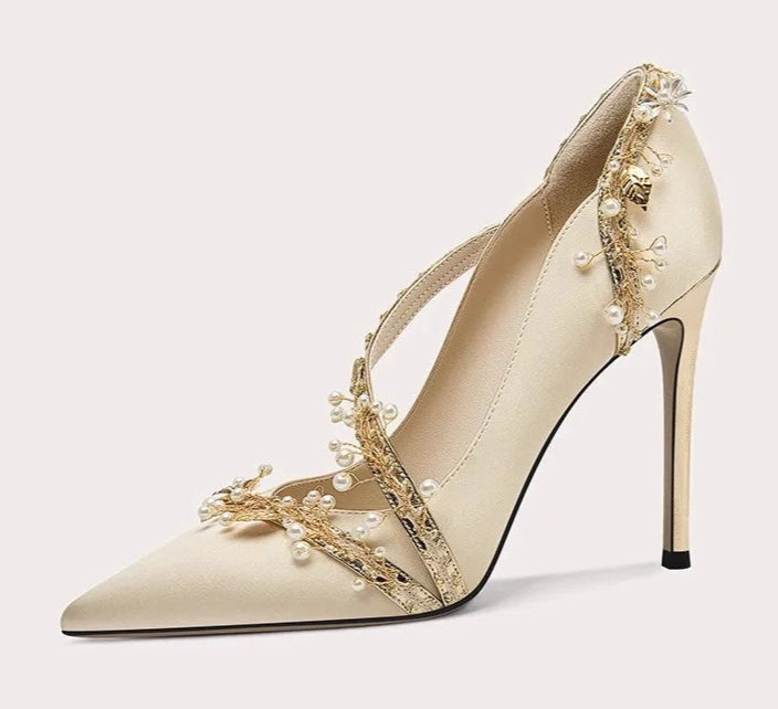 Beige high-heeled shoe with floral embellishments on a white background