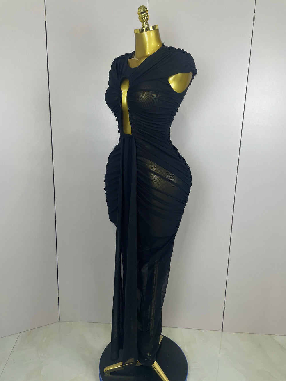 Black evening gown on a mannequin against a white background