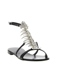 Black flat sandal with a silver rhinestone fishbone embellishment and ankle strap