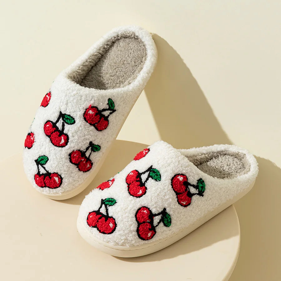 Pair of white plush cherry slippers on a light background