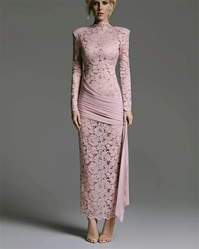 Woman wearing a pink lace dress against a gray background