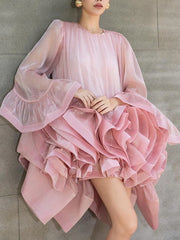 O-neck ruffled organza mini dress with bell sleeves against a grey wall.