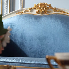 Blue upholstered chair with gold decorative headboard