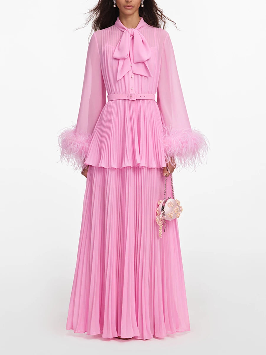 Pink pleated maxi dress with bow neck and feather trim