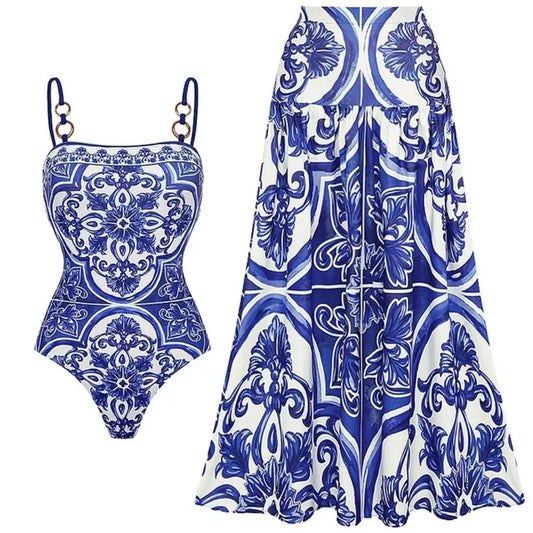 Blue and white tile print one-piece swimsuit and maxi skirt set laid flat.