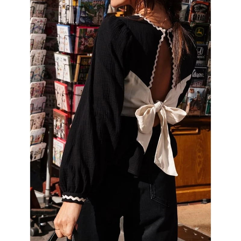 Person wearing a black outfit with white accents in a store setting