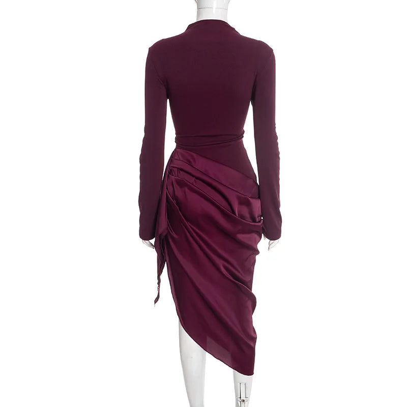Maroon dress with long sleeves and draped design on a white background