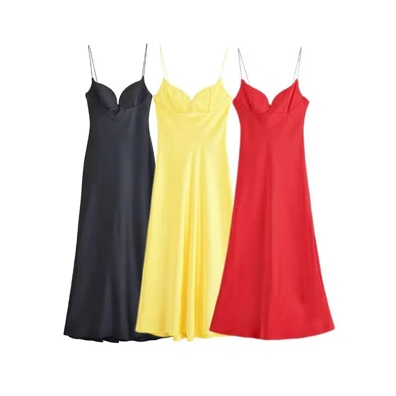 Three slip dresses in black, yellow, and red on a white background