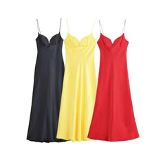 Three slip dresses in black, yellow, and red on a white background