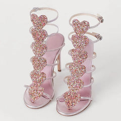 Women’s silver metallic open-toe sandals with glitter heart crystals.