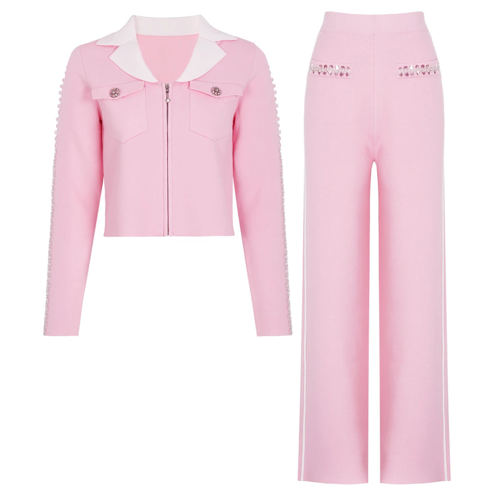 Pink knit jacket with white collar and embellished sleeves, paired with wide-leg pink trousers with white side stripes.