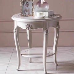 Decorative white side table with ornate legs against a neutral background