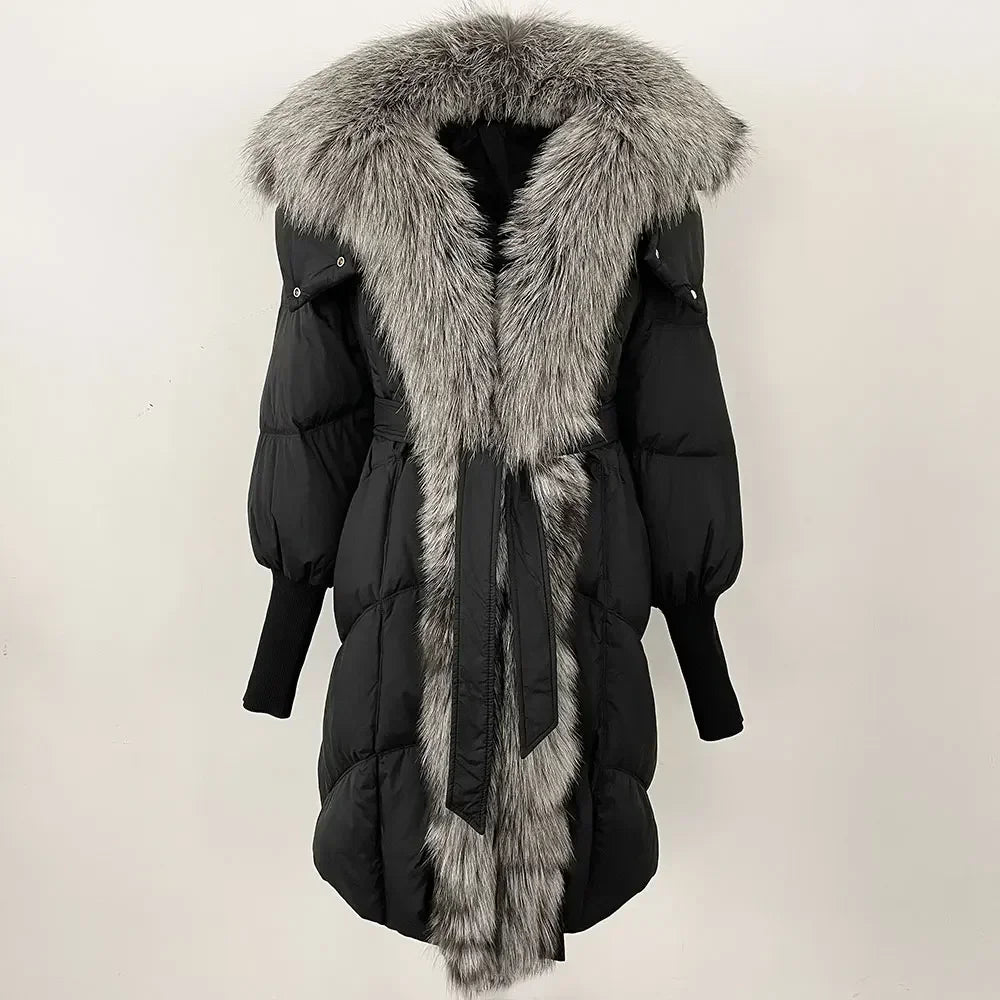 Black puffer coat with gray fur hood and trim on a light beige background