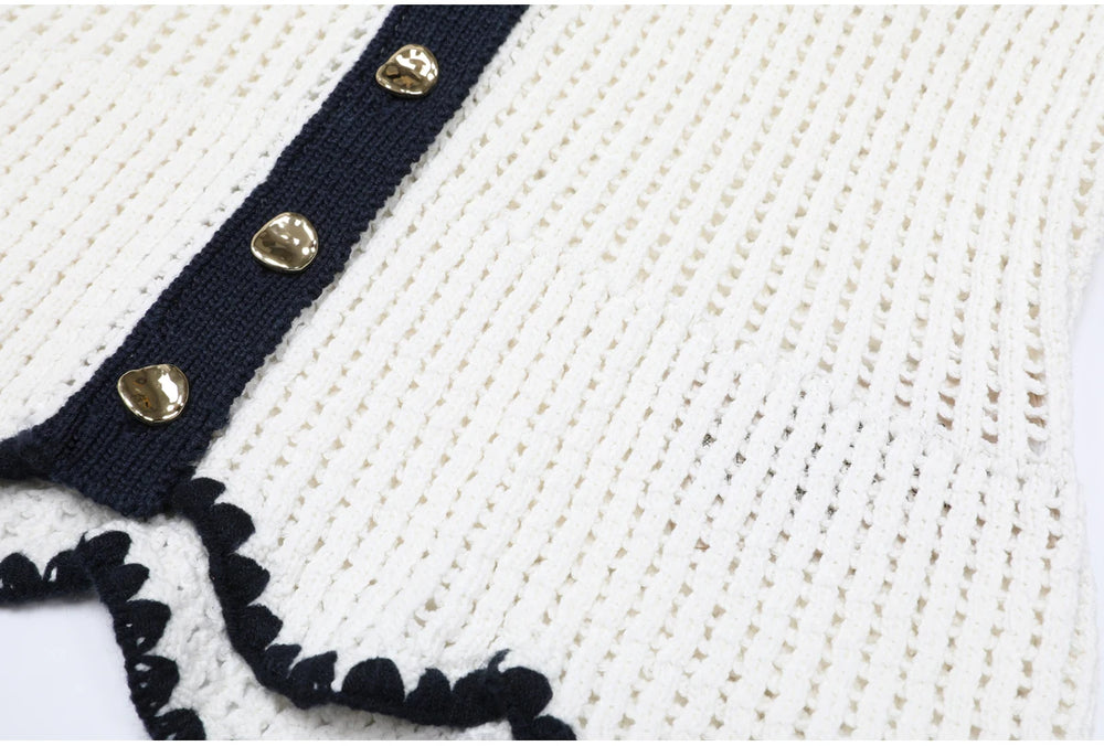 Close-up showing the knit texture and black trim on the hem of a white top