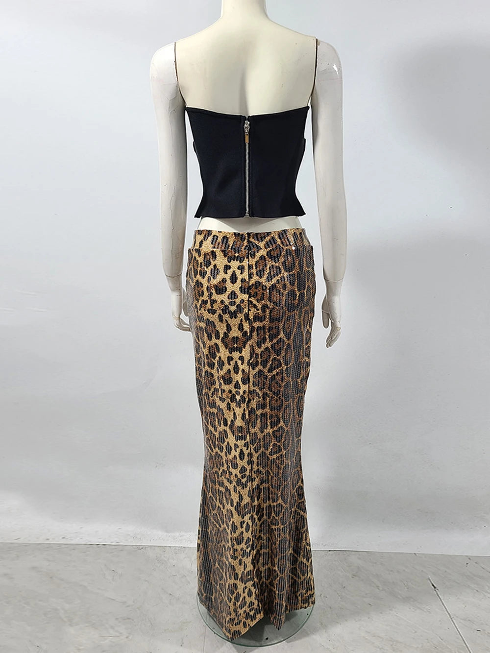 Mannequin wearing a black top and leopard print skirt against a white background
