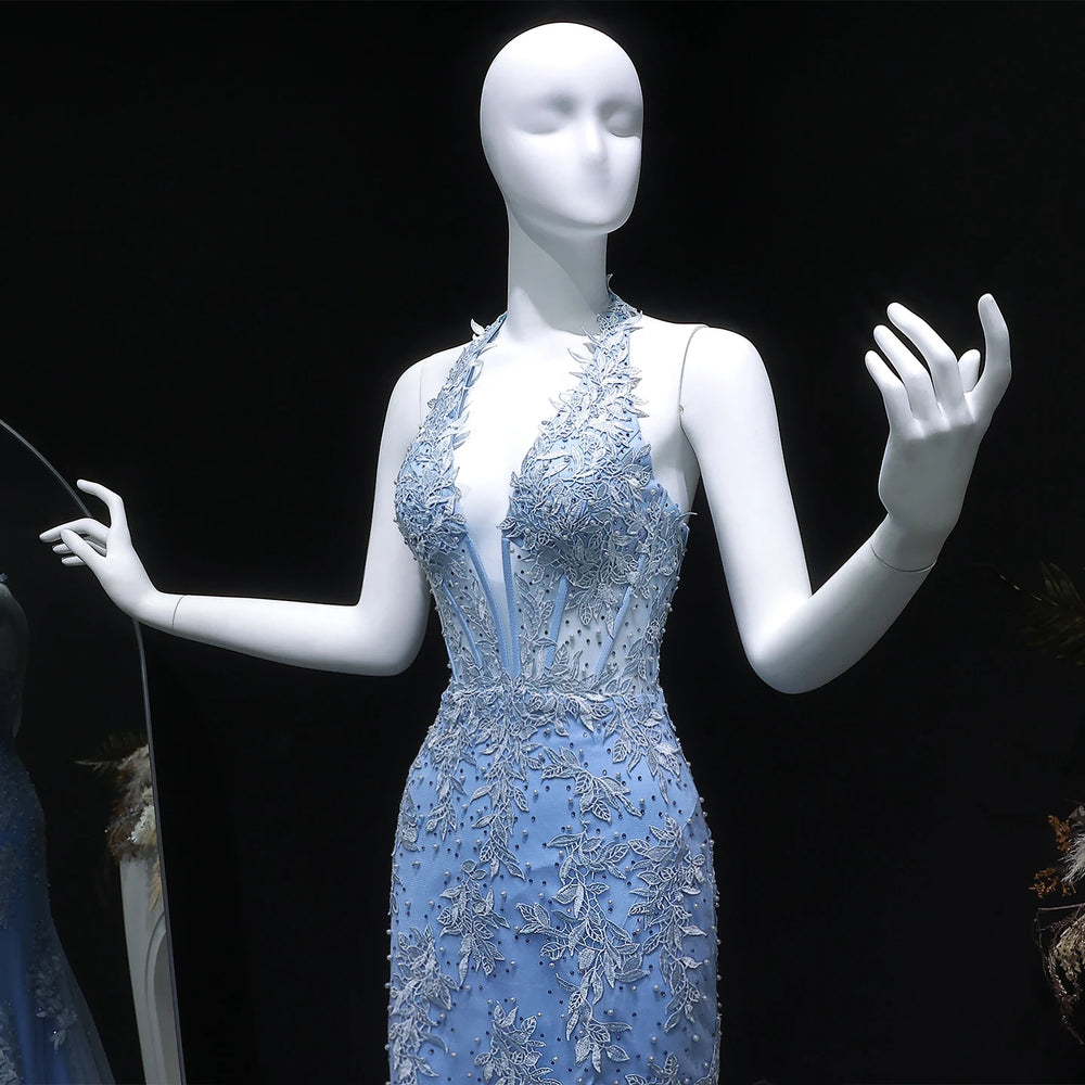 Mannequin wearing a light blue evening gown with intricate detailing on a black background