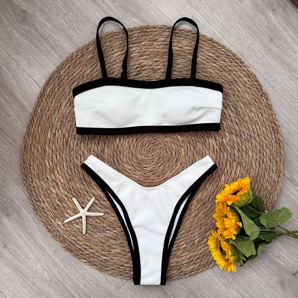 Textured bikini top and bottoms with black contrast trim laid flat.
