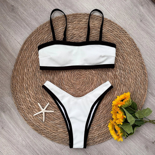 Textured bikini top and bottoms with black contrast trim laid flat.