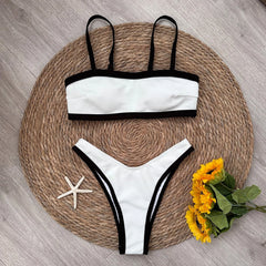 Textured bikini top and bottoms with black contrast trim laid flat.