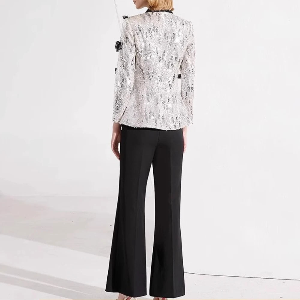 Person wearing a white lace blazer and black pants on a white background