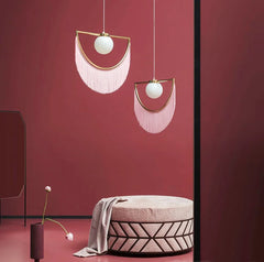 A pair of modern Nordic tassel chandelier with glass ball pendants hanging in a minimalist studio-room I.