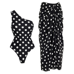 Black and white polka dot one-shoulder one-piece swimsuit with a matching draped sarong