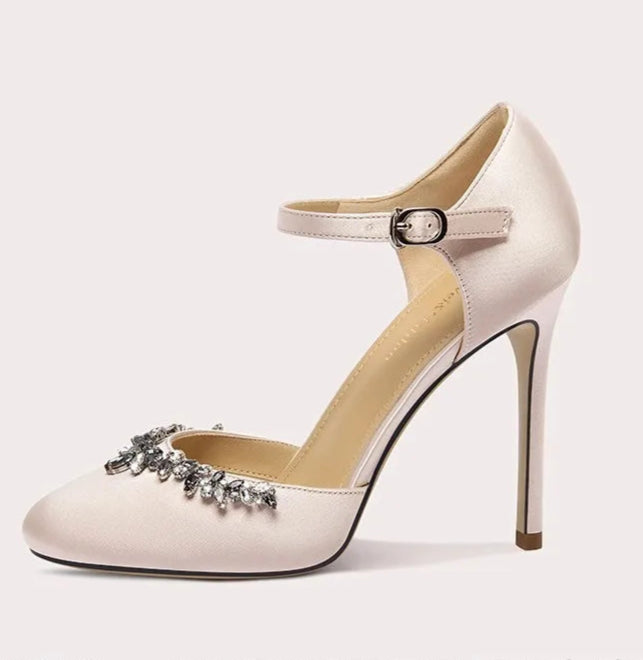 High-heeled shoe with decorative strap on a light gray background