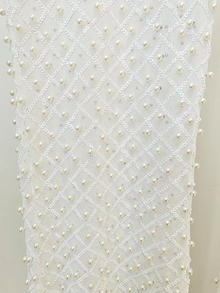 White fabric with a pattern of small pearls on a plain background