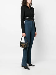 A stylish woman wearing a luxurious leather crossbody bag, showcasing its versatility and elegant design.