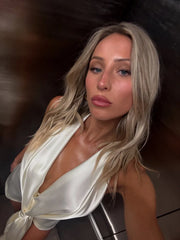 Woman wearing a white satin dress against a dark background