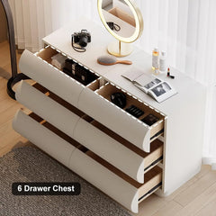 White dresser with six drawers in a room setting, featuring a camera, mirror, and other items.