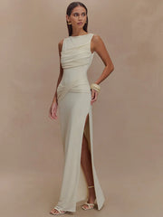 Woman wearing a flowing white dress with a slit on a beige background