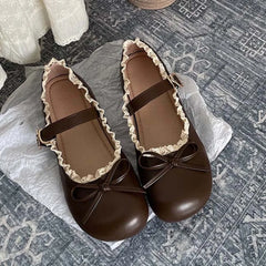 Brown lace ruffled bow Mary Jane flats on textured surface
