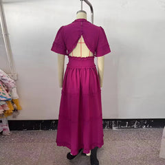Purple dress on a mannequin against a plain wall.