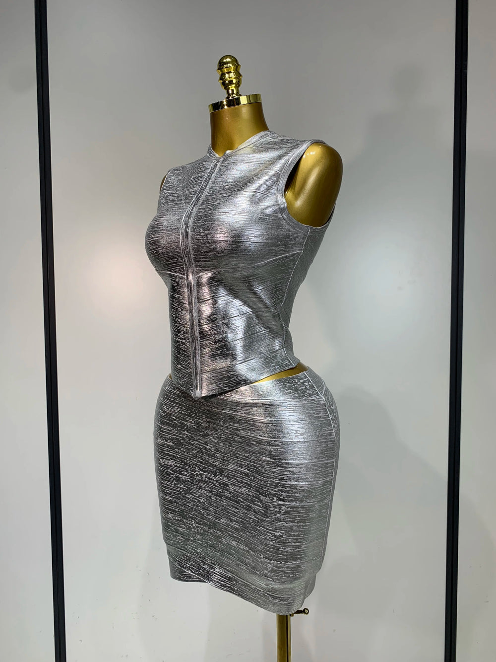 Silver mock neck sleeveless top and mini skirt set side profile