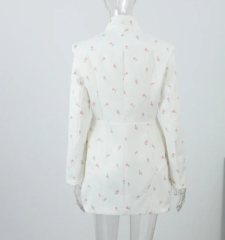 White dress with floral pattern on a mannequin against a plain background