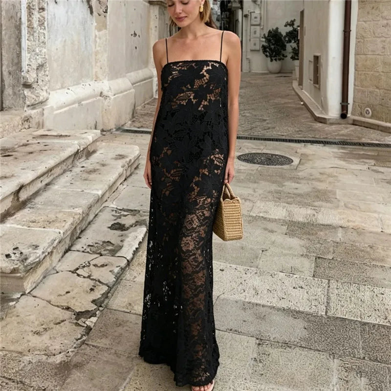 Sheer black floral lace maxi dress with spaghetti straps and straw bag