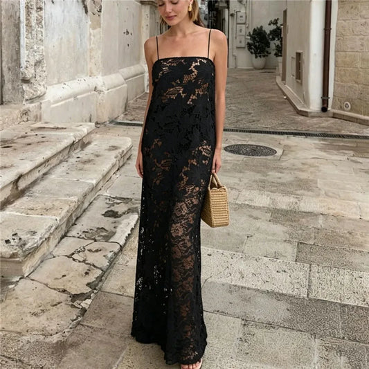 Sheer black floral lace maxi dress with spaghetti straps and straw bag