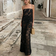 Sheer black floral lace maxi dress with spaghetti straps and straw bag