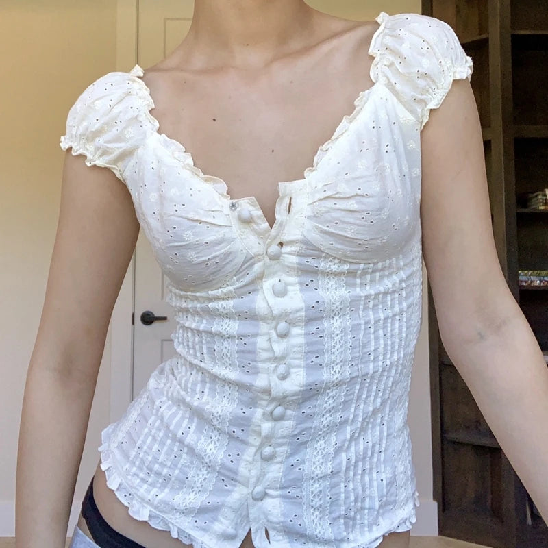 White embroidered top worn by a person indoors